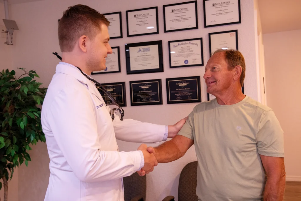 Dr. Dolecki smiling and shaking hands with a happy patient | Dentist in Punta Gorda, FL
